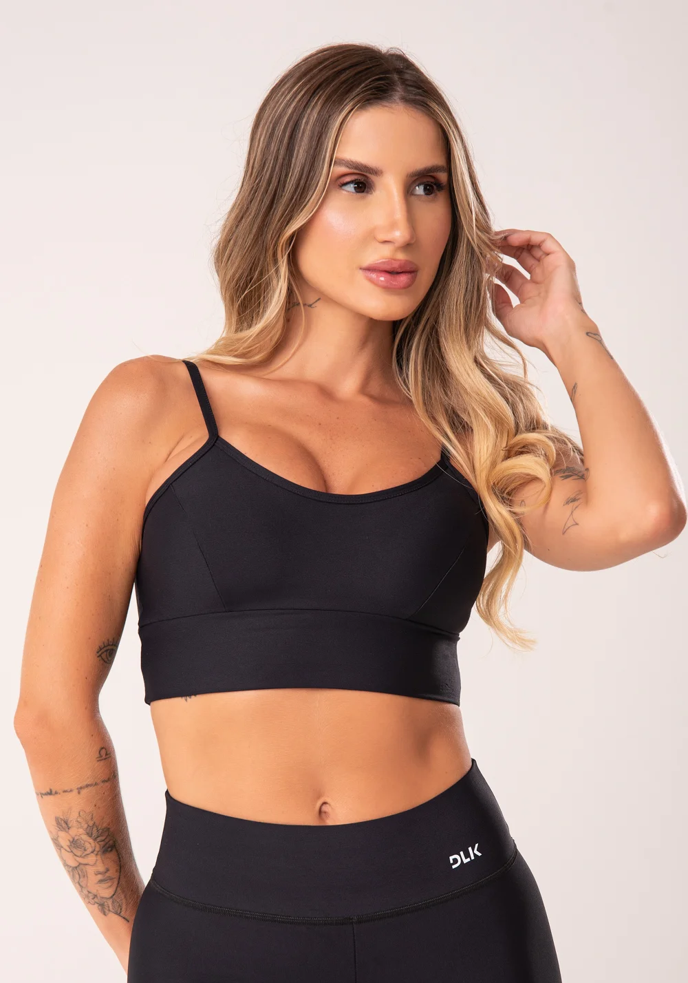 Top fitness preto com recortes e bojo básico dlk